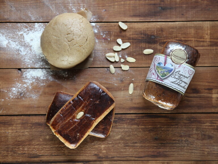 Ein frisches Stück Brot liegt auf einem rustikalen Holztisch.