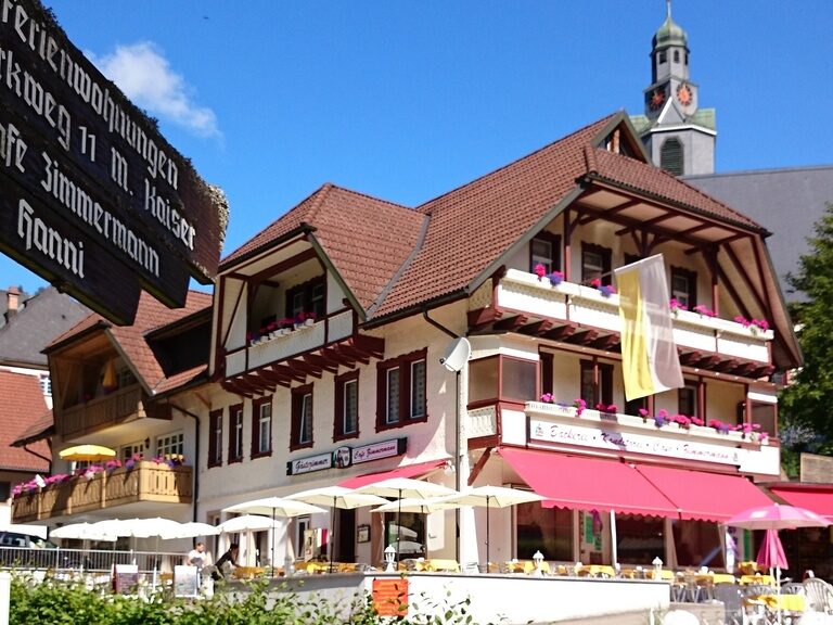 Das schöne Cafe Zimmermann in malerischer Umgebung mit einem Kirchturm im Hintergrund