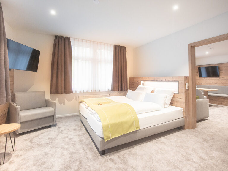 Ein stilvoll eingerichtetes Schlafzimmer mit Nachttisch in der Junior Suite des Hotels.